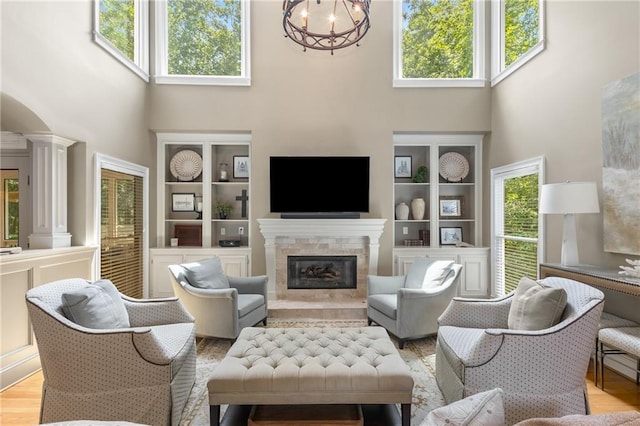 290 Edwardton Ct, Roswell, GA 30076 - living area with a towering ceiling, a premium fireplace, a chandelier, light wood-type flooring, and decorative columns