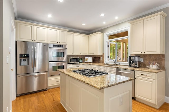 290 Edwardton Ct, Roswell, GA 30076 - kitchen featuring appliances with stainless steel finishes, crown molding, light wood-style flooring, light stone counters, and decorative backsplash