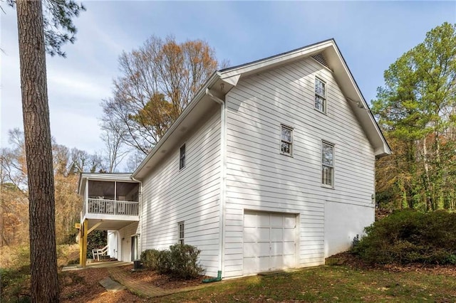 view of property exterior with a garage and a sunroom