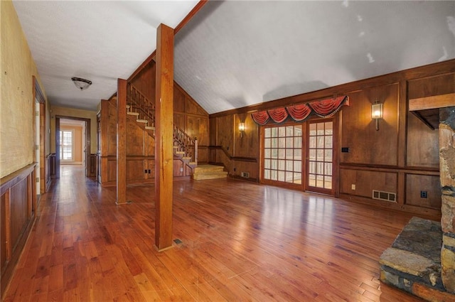 unfurnished living room featuring a fireplace, light wood-type flooring, and lofted ceiling