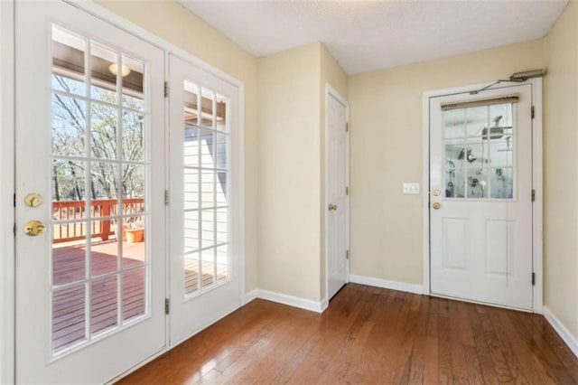 doorway featuring plenty of natural light, baseboards, and hardwood / wood-style flooring