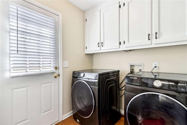 clothes washing area with cabinet space, baseboards, and separate washer and dryer