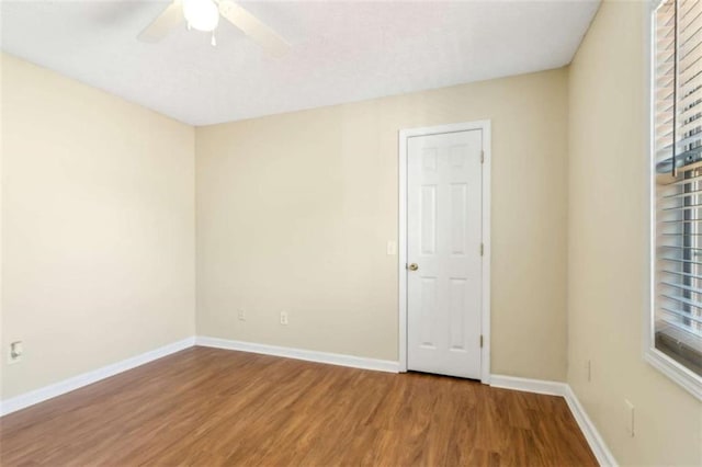 spare room with ceiling fan, baseboards, and wood finished floors