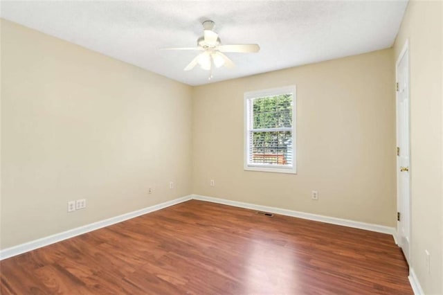 empty room featuring visible vents, ceiling fan, baseboards, and wood finished floors