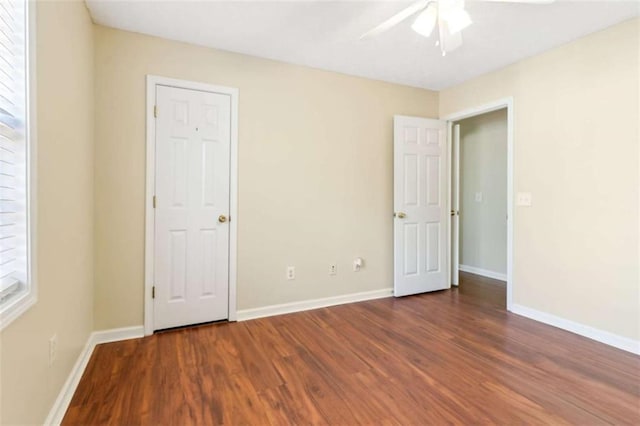 unfurnished room featuring a ceiling fan, baseboards, and wood finished floors