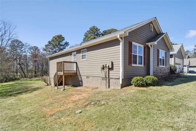 view of side of property with a garage, crawl space, and a lawn