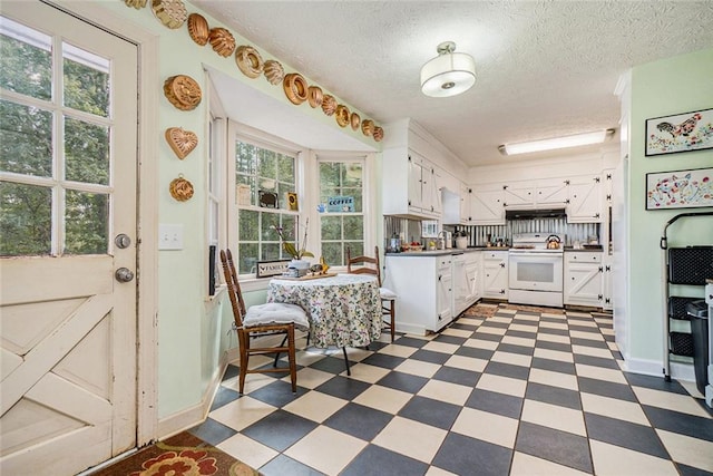 kitchen featuring electric range, backsplash, sink, white cabinetry, and a textured ceiling