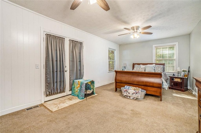 bedroom featuring ceiling fan, carpet floors, and a textured ceiling