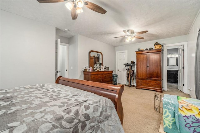 bedroom with a textured ceiling, ceiling fan, connected bathroom, and light colored carpet