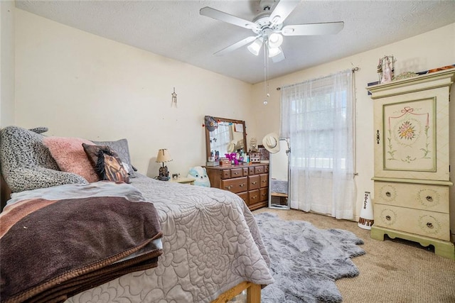 bedroom featuring light carpet, a textured ceiling, and ceiling fan