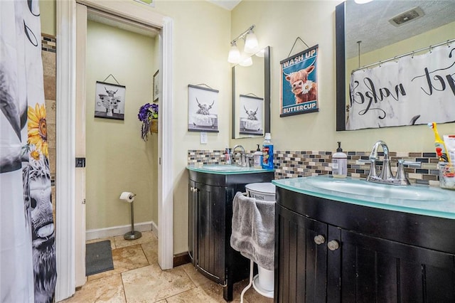 bathroom with tasteful backsplash and vanity