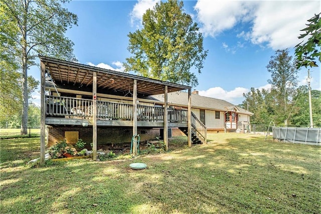 rear view of property with a wooden deck and a lawn