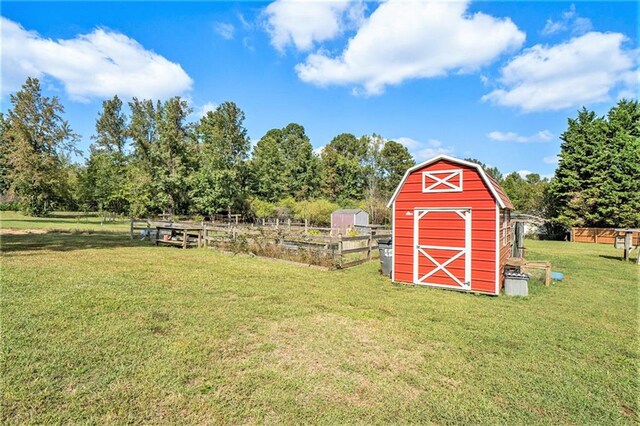 view of outbuilding featuring a rural view and a lawn