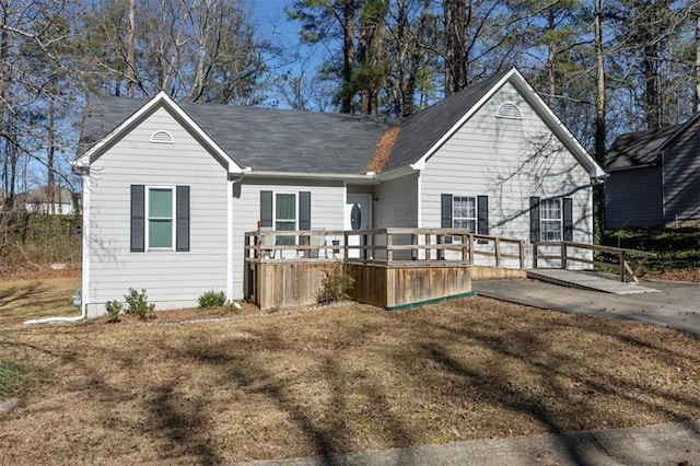 rear view of house featuring a yard and a deck