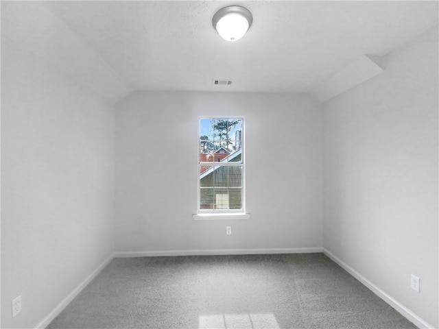 empty room with carpet and vaulted ceiling