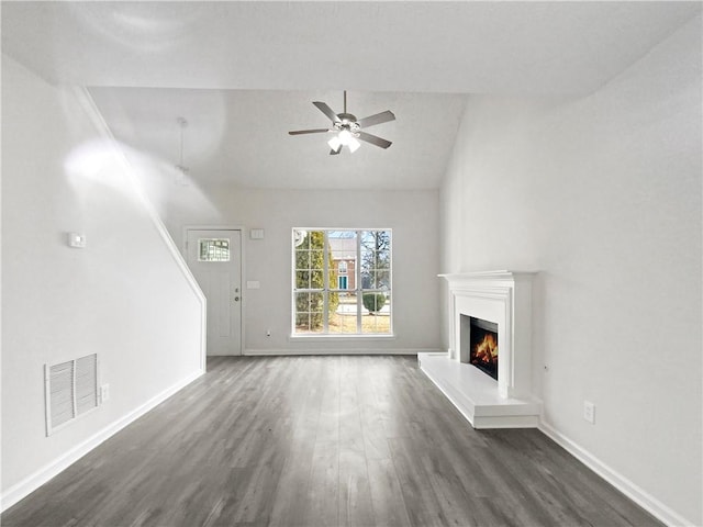 unfurnished living room with ceiling fan, dark hardwood / wood-style floors, and vaulted ceiling