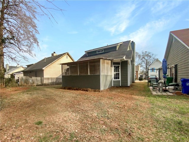 back of house with a sunroom and a yard