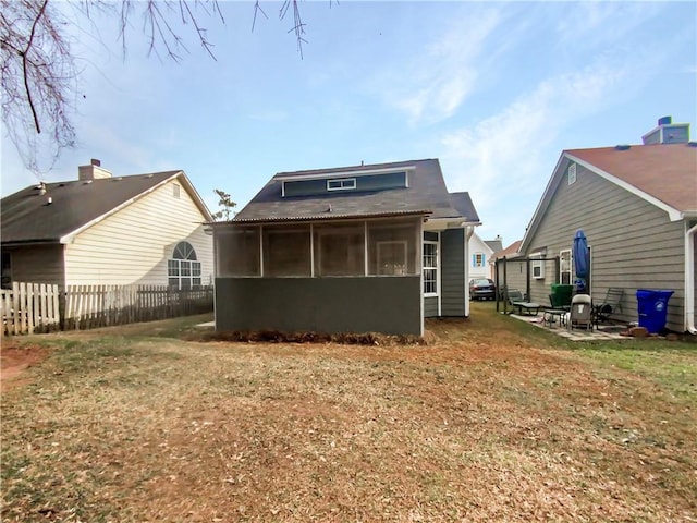 rear view of property featuring a lawn and a sunroom