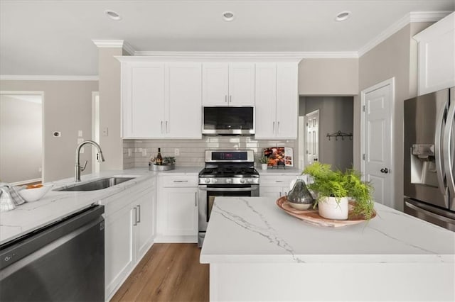 2870 Tattersall Ct, Cumming, GA 30041 - kitchen featuring stainless steel appliances, a sink, backsplash, ornamental molding, and white cabinetry