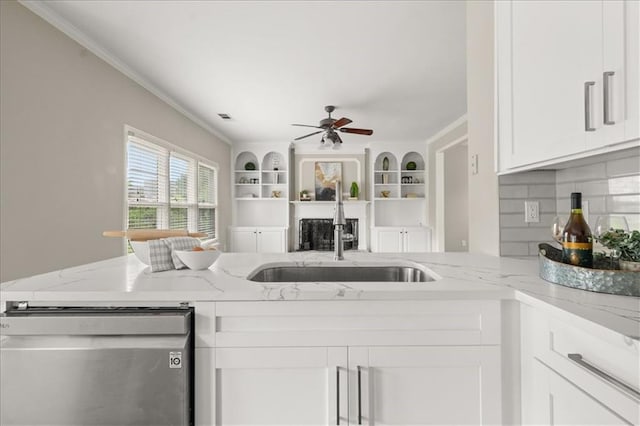 2870 Tattersall Ct, Cumming, GA 30041 - kitchen featuring a sink, dishwasher, ornamental molding, a ceiling fan, and light stone counters