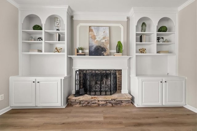 2870 Tattersall Ct, Cumming, GA 30041 - living area featuring wood finished floors, ornamental molding, built in features, a fireplace with raised hearth, and baseboards