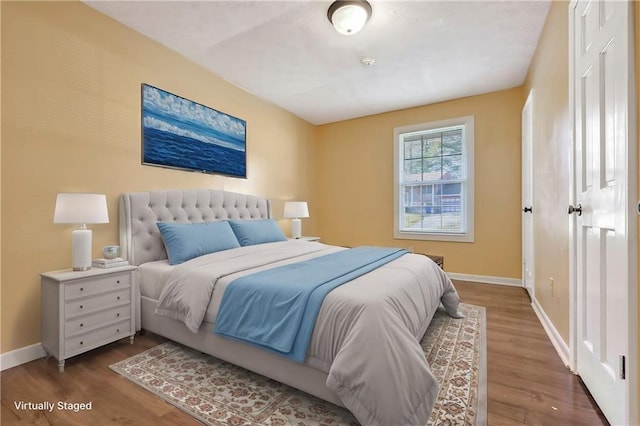 bedroom with wood finished floors and baseboards