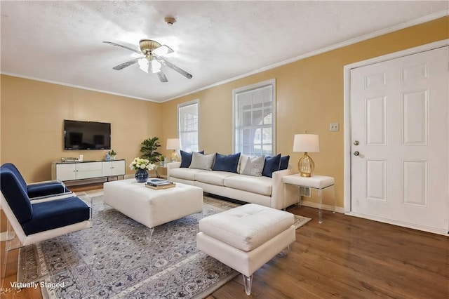 living room with a ceiling fan, wood finished floors, baseboards, and ornamental molding