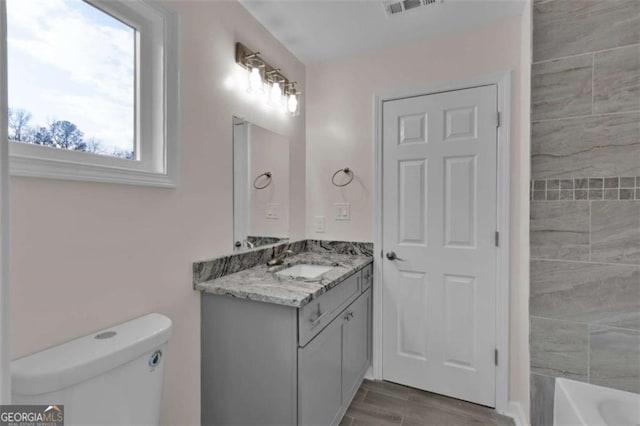 250 Stonecreek Pkwy, Covington, GA 30016 - bathroom featuring vanity, a bath, and wood finished floors