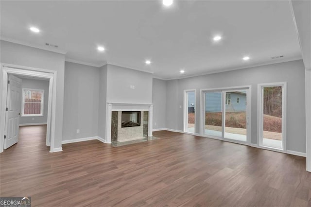 250 Stonecreek Pkwy, Covington, GA 30016 - unfurnished living room with crown molding, healthy amount of natural light, wood finished floors, recessed lighting, and a fireplace with flush hearth