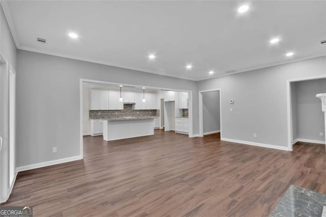250 Stonecreek Pkwy, Covington, GA 30016 - unfurnished living room with crown molding, dark wood-style flooring, and recessed lighting