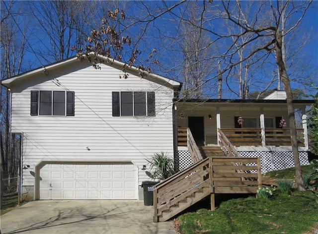 view of front of house featuring stairs, concrete driveway, an attached garage, and covered porch