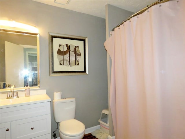 bathroom with vanity, a shower with shower curtain, toilet, and baseboards