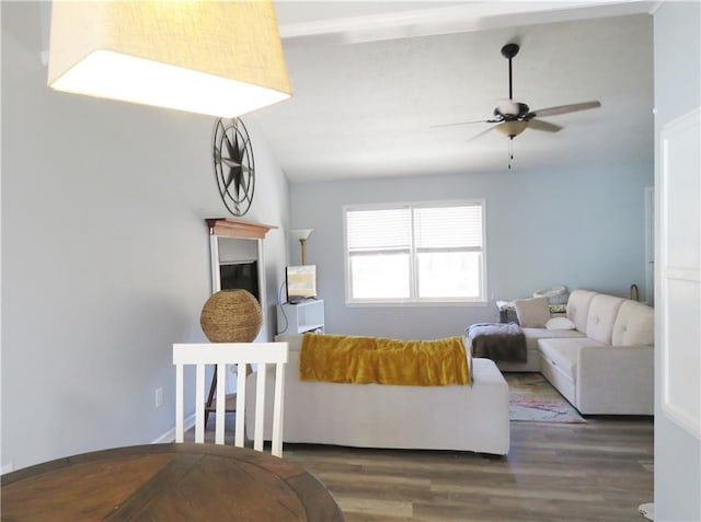 living room featuring wood finished floors, a ceiling fan, and vaulted ceiling