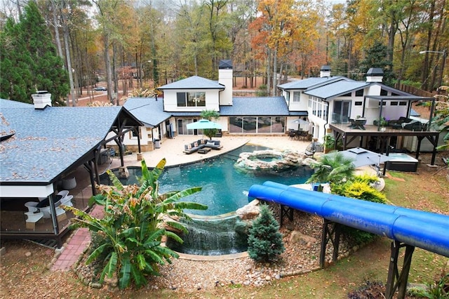 view of swimming pool featuring an in ground hot tub, a patio, an outdoor hangout area, and a sunroom