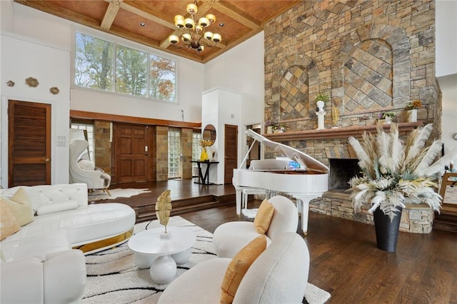 interior space featuring coffered ceiling, a high ceiling, dark hardwood / wood-style floors, a notable chandelier, and a fireplace