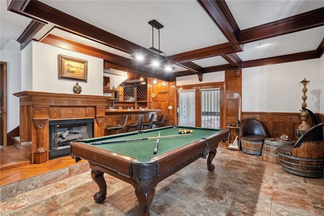 game room featuring pool table, crown molding, beamed ceiling, bar area, and wood walls