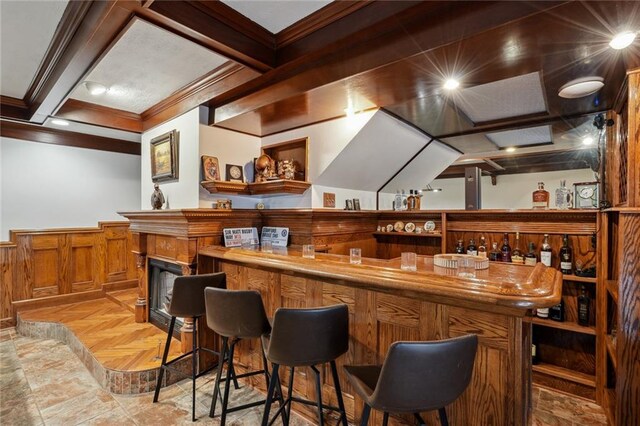 bar with beam ceiling, light parquet flooring, and ornamental molding