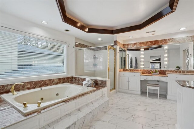 bathroom with a raised ceiling, vanity, and independent shower and bath