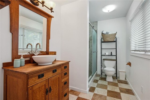 bathroom with vanity, a healthy amount of sunlight, and a shower with shower door