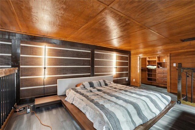 bedroom with wooden walls, wood ceiling, and dark hardwood / wood-style floors