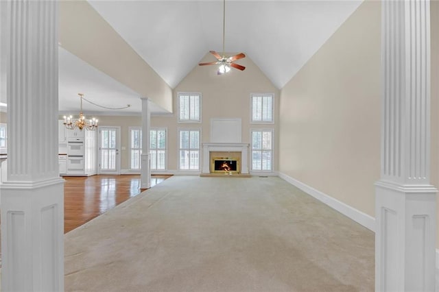 1405 Wilmington Way, Grayson, GA 30017 - unfurnished living room featuring decorative columns, a ceiling fan, a warm lit fireplace, high vaulted ceiling, and baseboards