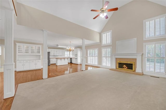 1405 Wilmington Way, Grayson, GA 30017 - unfurnished living room featuring ornate columns, a lit fireplace, light wood finished floors, and high vaulted ceiling