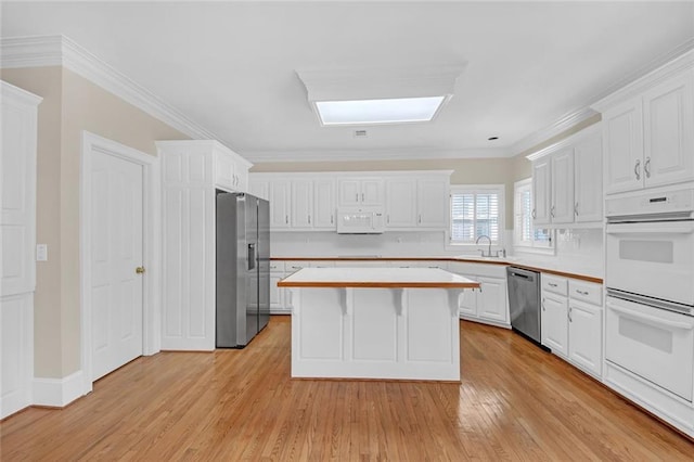 1405 Wilmington Way, Grayson, GA 30017 - kitchen with stainless steel appliances, a sink, white cabinets, light countertops, and a kitchen island