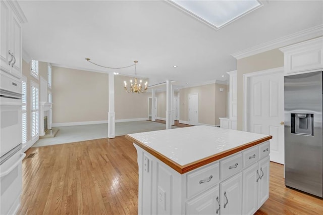 1405 Wilmington Way, Grayson, GA 30017 - kitchen with stainless steel fridge with ice dispenser, crown molding, a chandelier, light wood-type flooring, and white cabinetry