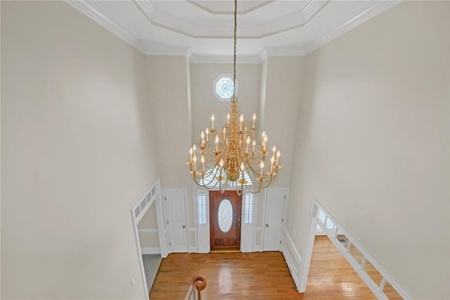 1405 Wilmington Way, Grayson, GA 30017 - foyer with wood finished floors, a chandelier, a high ceiling, a raised ceiling, and crown molding