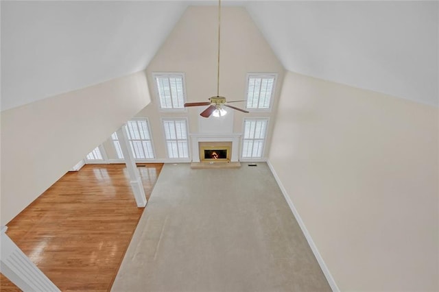 1405 Wilmington Way, Grayson, GA 30017 - unfurnished living room featuring a ceiling fan, a high end fireplace, high vaulted ceiling, baseboards, and wood finished floors