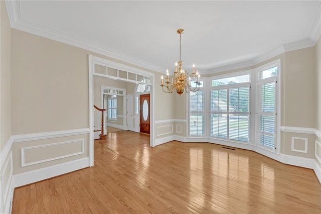 1405 Wilmington Way, Grayson, GA 30017 - unfurnished dining area featuring a decorative wall, a chandelier, ornamental molding, light wood-type flooring, and wainscoting