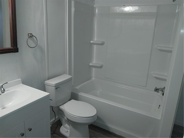 bathroom with vanity, wood finished floors, toilet, and washtub / shower combination