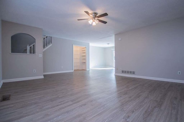 spare room featuring a textured ceiling, dark wood-type flooring, and ceiling fan