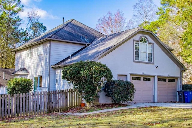 view of side of home with a garage and a yard